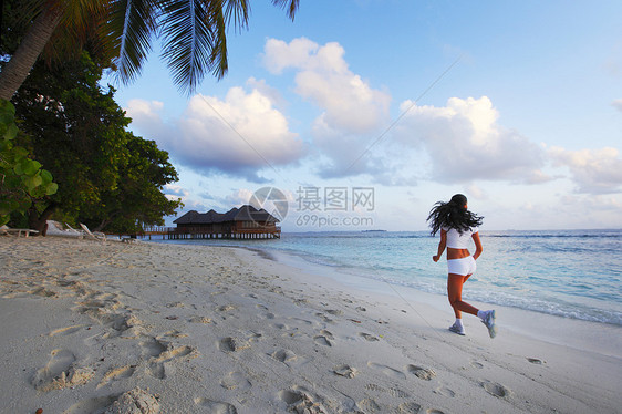 女人在海滩上奔跑蓝色赛跑者海洋黑发运动慢跑者天空日落女孩跑步图片