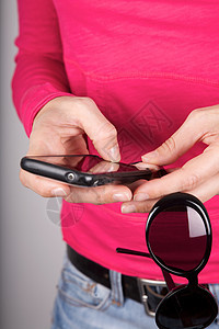 带智能手机的粉红色毛衣妇女图片