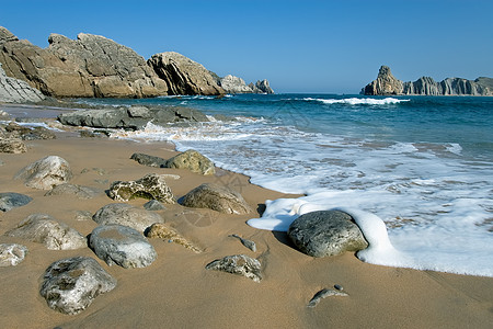 西班牙坎塔布里亚Liencres海滩石头海洋岩石太阳留置晴天图片