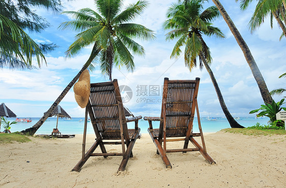 美丽的海滩 有棕榈树假期游客海景热带阳伞天空棕榈海岸线遮阳棚椅子图片