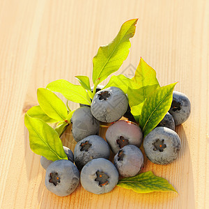 木制桌上的蓝莓蓝色团体桌子覆盆子水果叶子食物木头图片