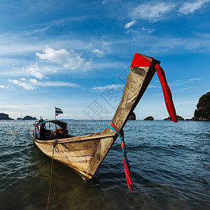 泰国海滩上长尾船日落岩石热带天空蓝色旅行石头旅游图片