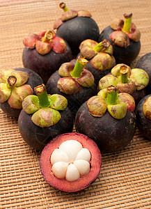 竹垫背景的芒果维生素异能热带食物反射水果山竹藤黄营养紫色背景图片