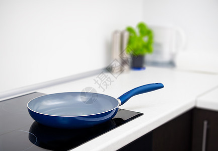 在现代厨房用上岗炉灶煎锅陶瓷制品工作玻璃盘子蓝色器具橱柜柜台食物图片
