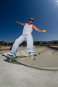 混凝土池中的滑板机车轮男人太阳青少年活力牛仔裤娱乐城市运动木板图片