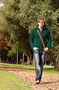 寒秋日行走的聪明人晴天青年毛衣男性季节公园木头照片眼镜学生图片