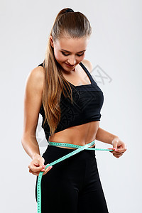 快乐的女孩用尺子测量腰部数字成人蓝色饮食女性磁带女士运动身体统治者图片