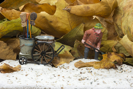 男人用扫马车打扫车皮车轮玩具黑色工人扫帚运输棕色工作树叶图片