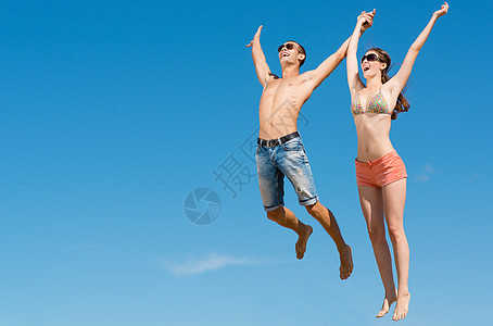 年轻夫妇一起跳跃女孩胜利场地空气男生乐趣家庭女士衣服公司图片