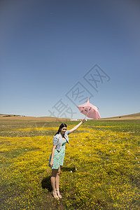 美丽的成年人在阳光明媚的田野上闻着鲜花的香味植物乐趣女性日落太阳镜女孩田园种子活动休闲图片