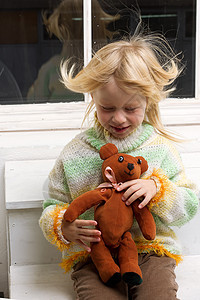 带着玩具的小女孩 流着头发的毛发窗户活力乘客行动孩子们女性空气笑声毛衣发型图片