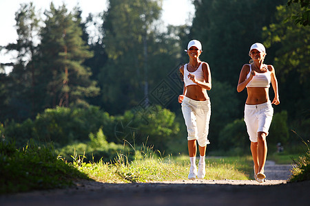 参加竞选的妇女女士火车跑步头发锻炼树木慢跑女性运动装公园图片