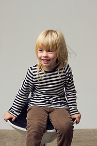 穿着牛仔裤的3岁女孩坐在高椅子上金发靴子宝贝高脚椅衬衫孩子女性卷曲夹克凳子图片