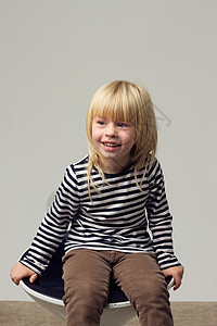 穿着牛仔裤的3岁女孩坐在高椅子上宝贝头发卷曲纺纱孩子凳子夹克高脚椅衬衫金发图片