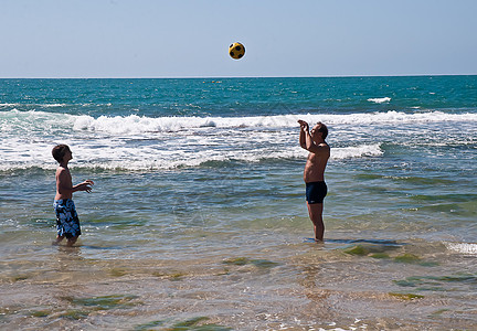 快乐的父亲和儿子在玩球男性海滩阳光生活活力孩子旅行自由父母家庭图片