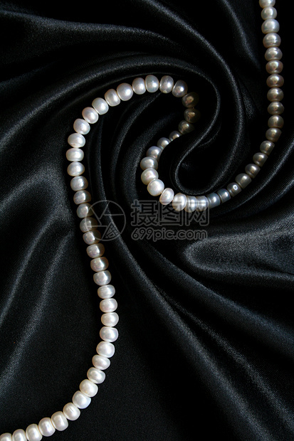 黑色丝绸上的白珍珠作为背景珠子细绳礼物奢华珠宝象牙光泽度宝石魅力宝藏图片