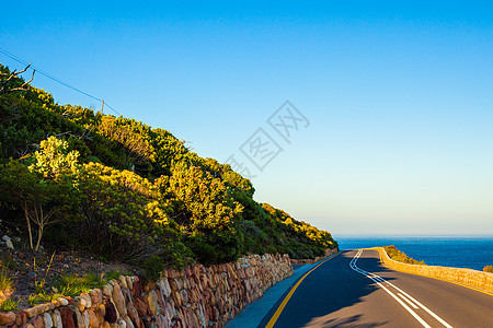 海滨弯曲路海岸线地平线驾驶海洋晴天蓝色天空太阳悬崖海湾图片