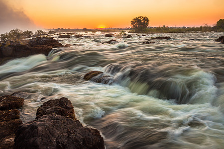 维多利亚瀑布的白水急流激流日落瀑布溪流水域橙子野生动物岩石河岸边缘图片
