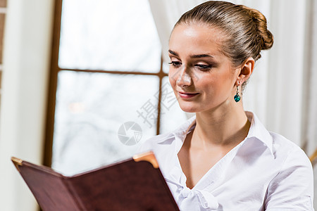餐厅一位好女士的肖像女孩享受食堂桌子快乐服务午餐阅读头发成人图片
