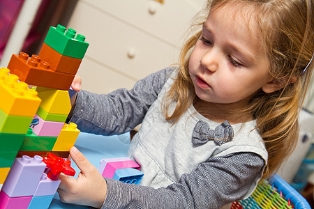 小女孩在玩砖头的木砖快乐教育学习学校房间托儿所苗圃乐趣青年地毯图片