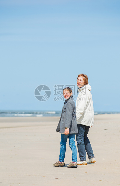 女孩和祖母在海滩上散步跑步女性娱乐天堂微笑友谊乐趣运动天空女士图片