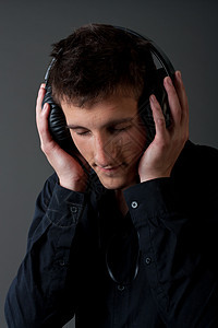 男性青年听音乐者立体声歌曲享受男人耳机黑色乐趣灰色技术娱乐图片