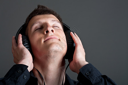 男性青年听音乐者音乐黑色乐趣技术享受灰色歌曲立体声娱乐耳机图片