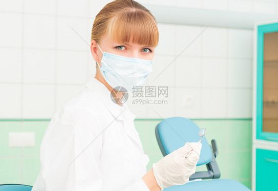 戴保护面罩的女牙医椅子保健诊所助手专家金发相机情况工作面具图片