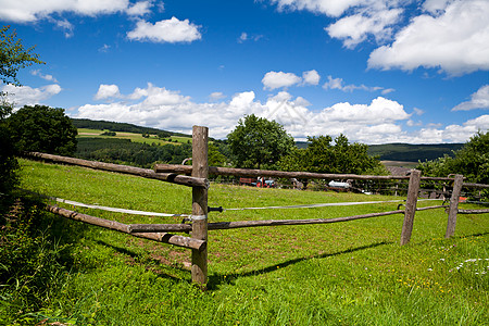 绿草地上的木栅栏白色爬坡绿色晴天天空场地云景村庄草地木头图片