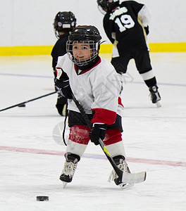 小男孩打冰曲棍球孩子球衣游戏冰鞋运动员冰球青年娱乐团队曲棍图片