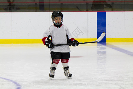 小男孩打冰曲棍球冰球童年木板竞争冰鞋运动闲暇乐趣球衣娱乐图片