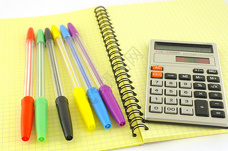 黄色书本上的旧计算器和彩色笔软垫绘画笔记笔记本笔记纸会议记事本邮政羽毛桌子图片