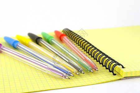 黄色书写簿上的彩色笔文档紫色文书笔记笔记纸工作桌子线条备忘录羽毛图片