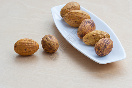 棕色的坚果 躺在一排不离的盘子上饮食腰果杏仁水果团体营养宏观种子飞碟桌子图片