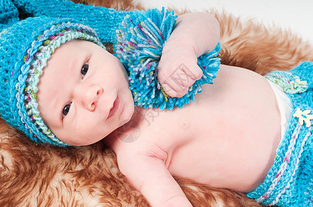 戴长蓝色编织帽的新生婴儿图片