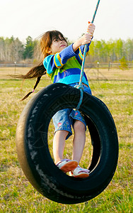 小女孩在乡下轮胎挥舞着轮胎秋千图片