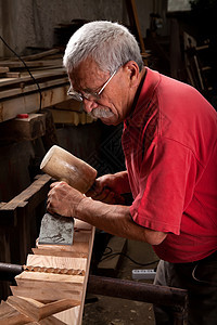 木制木雕 用球棒和锯子工作传统雕刻木头工人雕刻师木板划痕雕塑飞机木制品图片