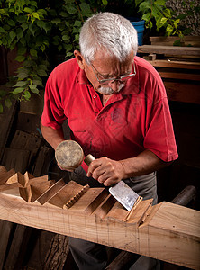 使用球棒工作的老木雕雕刻手工雕刻师木头飞机锤子划痕木材松树木制品图片