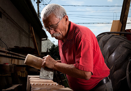 使用球棒工作的老木雕木头雕刻师家具工人飞机构造木匠木板手工工艺图片