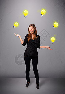 年轻女士站立和玩弄灯泡戏法者微笑游戏照明戏法专注运动女性控制快乐图片