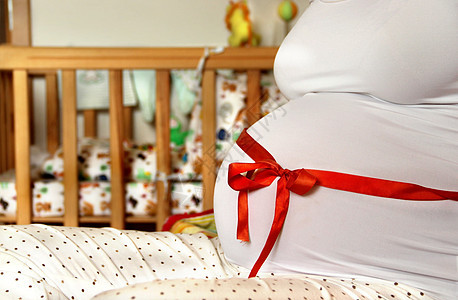 美丽的怀孕孕妇肚子里母亲分娩展示房间孩子婴儿配件礼物玩具父母图片