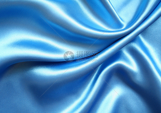 平滑优雅的蓝色丝绸作为背景布料感性纺织品材料投标曲线织物海浪版税折痕图片