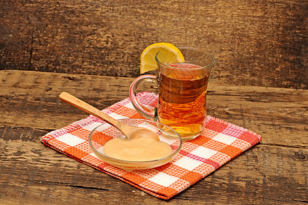 彩色餐巾纸上加蜂蜜的一杯茶餐厅玻璃液体荒野柠檬草本植物早餐蜜蜂药品水果图片
