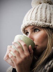 喝咖啡或茶的美丽的年轻女孩杯子羊毛衣服围巾早餐可可咖啡饮料图片