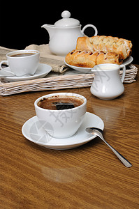 一杯黑咖啡 一个奶工和一盘糕点咖啡勺子香料杯子酿造餐饮蛋糕托盘飞碟桌子图片