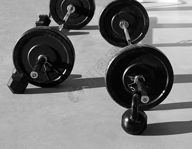 在交叉式健身房用举起巴重量的餐铃俱乐部哑铃倒钩身体健美训练运动员运动培训师锻炼图片