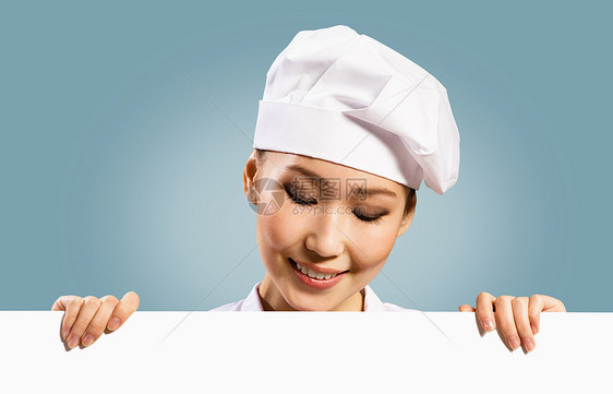 持有文本海报的女厨师微笑助手女孩衣服餐厅面包师厨房木板食物广告图片
