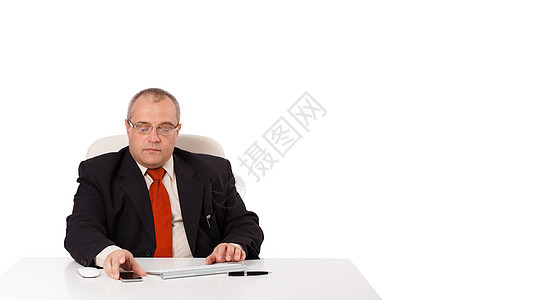 商务人士坐在办公桌旁 用复印件看移动电话图片