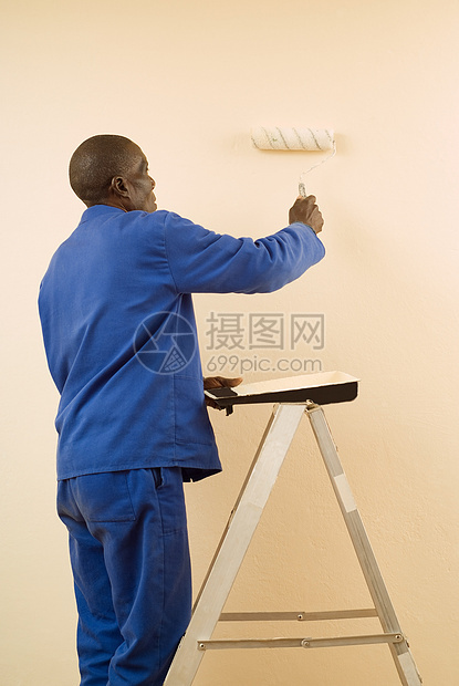 使用绘画卷的绘画器补给品男人石膏板承包商工人材料装修房子住宅外套图片