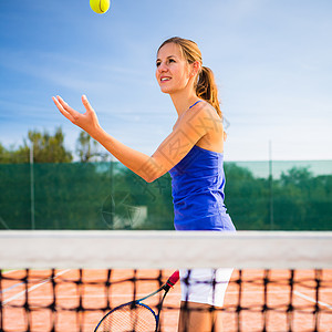 一个漂亮的年轻网球运动员的肖像成功速度闲暇运动微笑活力天空女士蓝色训练图片